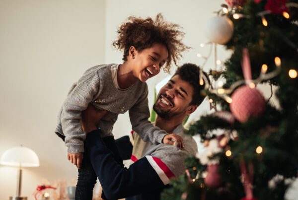 Adult and Child around Christmas tree